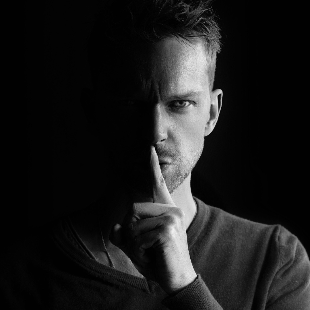 Mann mit Fingervor dem Mund, psst