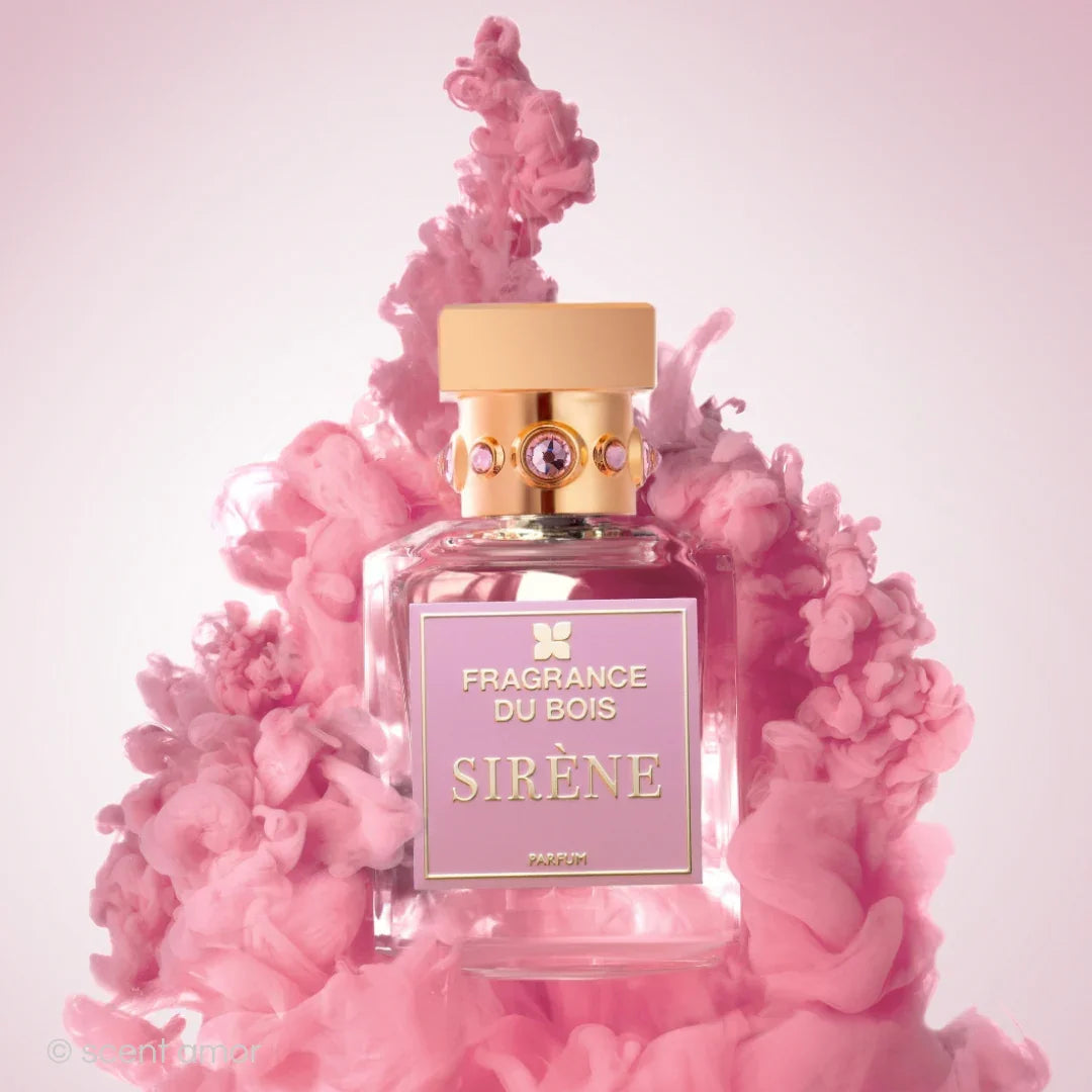 Ein Parfümflakon mit der Aufschrift "FRAGRANCE DU BOIS SIRÈNE", umgeben von rosa Rauchschwaden. Der Flakon hat einen goldenen Verschluss.