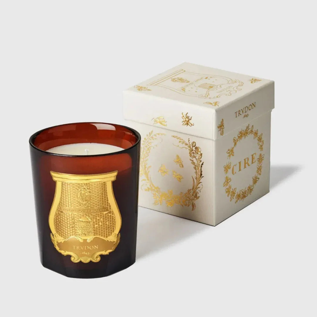 Duftkerze "CIRE" von Trudon in einem braunen Glas mit goldenem Emblem, neben einer dekorativen, verzierten Box.