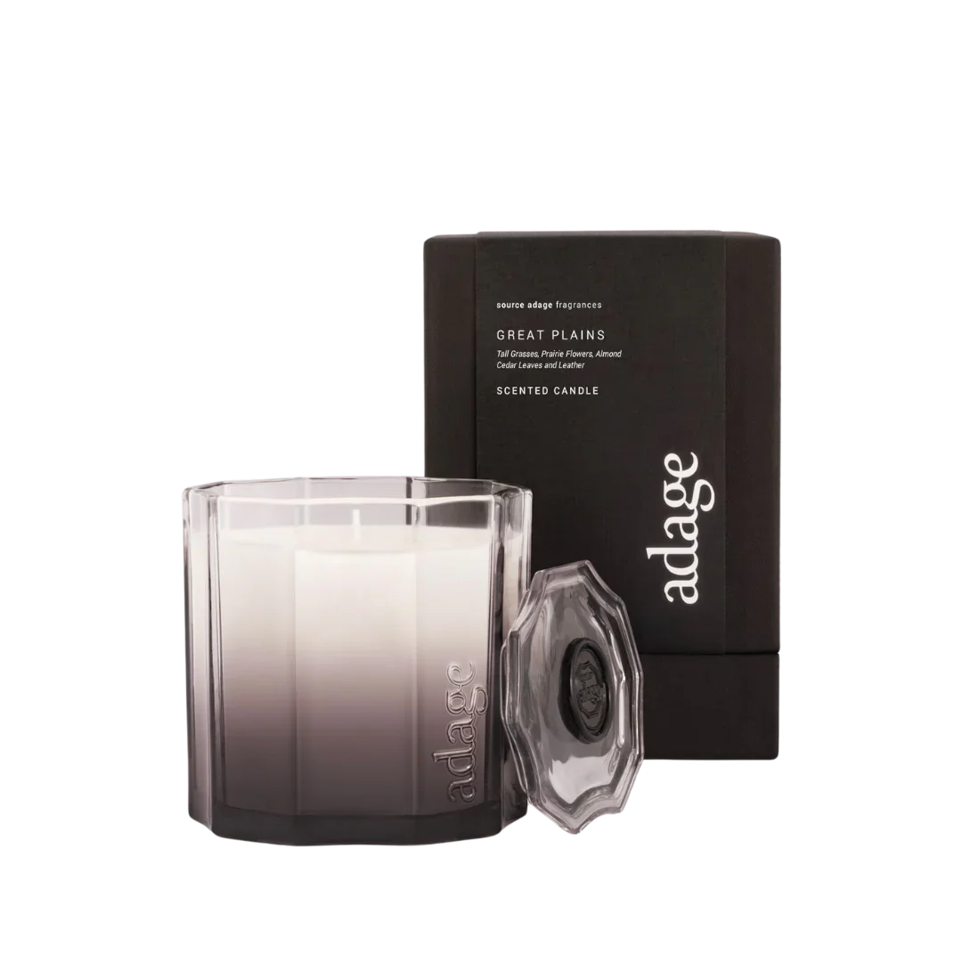 Duftkerze "Great Plains" von source adage in einem runden, transparenten und mit "adage" geprägten Glas. Im Hintergrund eine schwarze Verpackung.