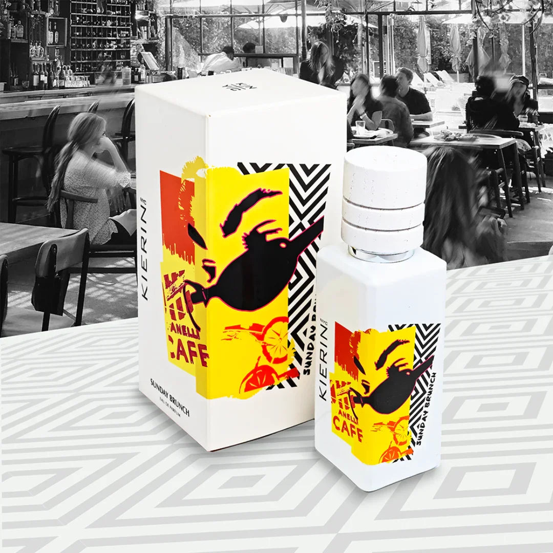 Parfümflasche mit weißem Zerstäuber und bunter, grafischer Gestaltung zeigt "Sunday Brunch" von Kierin NYC. Daneben steht eine passende Schachtel mit gleichem Design.