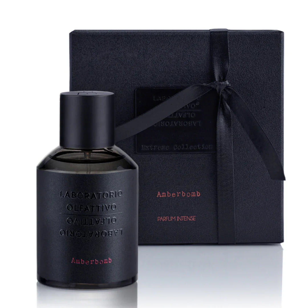 Amberfarbenes Parfumfläschchen "Amberbomb" von Laboratorio Olfattivo, mit schwarzer Verpackung und Schleife.