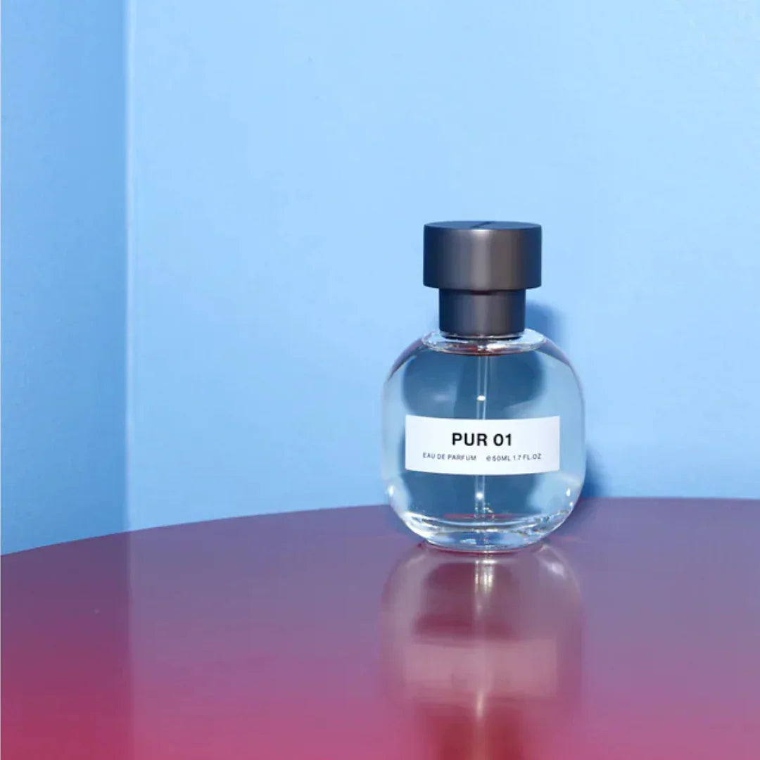 Das Produkt "PUR 01" von "SON VENÏN" ist ein rundes Parfümflakon mit schwarzem Verschluss und einem weißen Etikett.