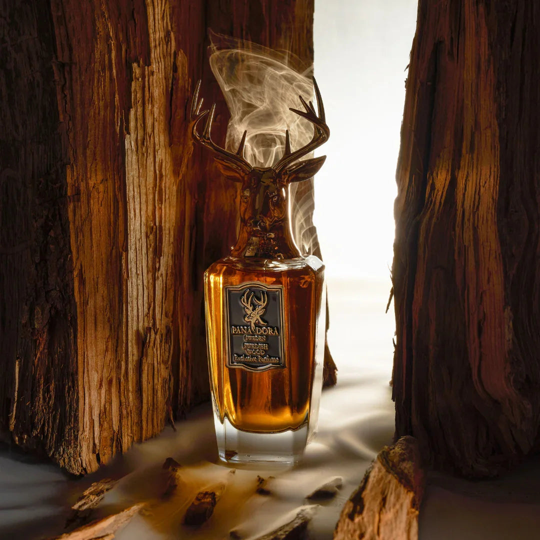 Braune Flasche mit markantem Hirschkopfverschluss, "Swedish Wood" von Pana Dora, zwischen Holzstämmen positioniert.