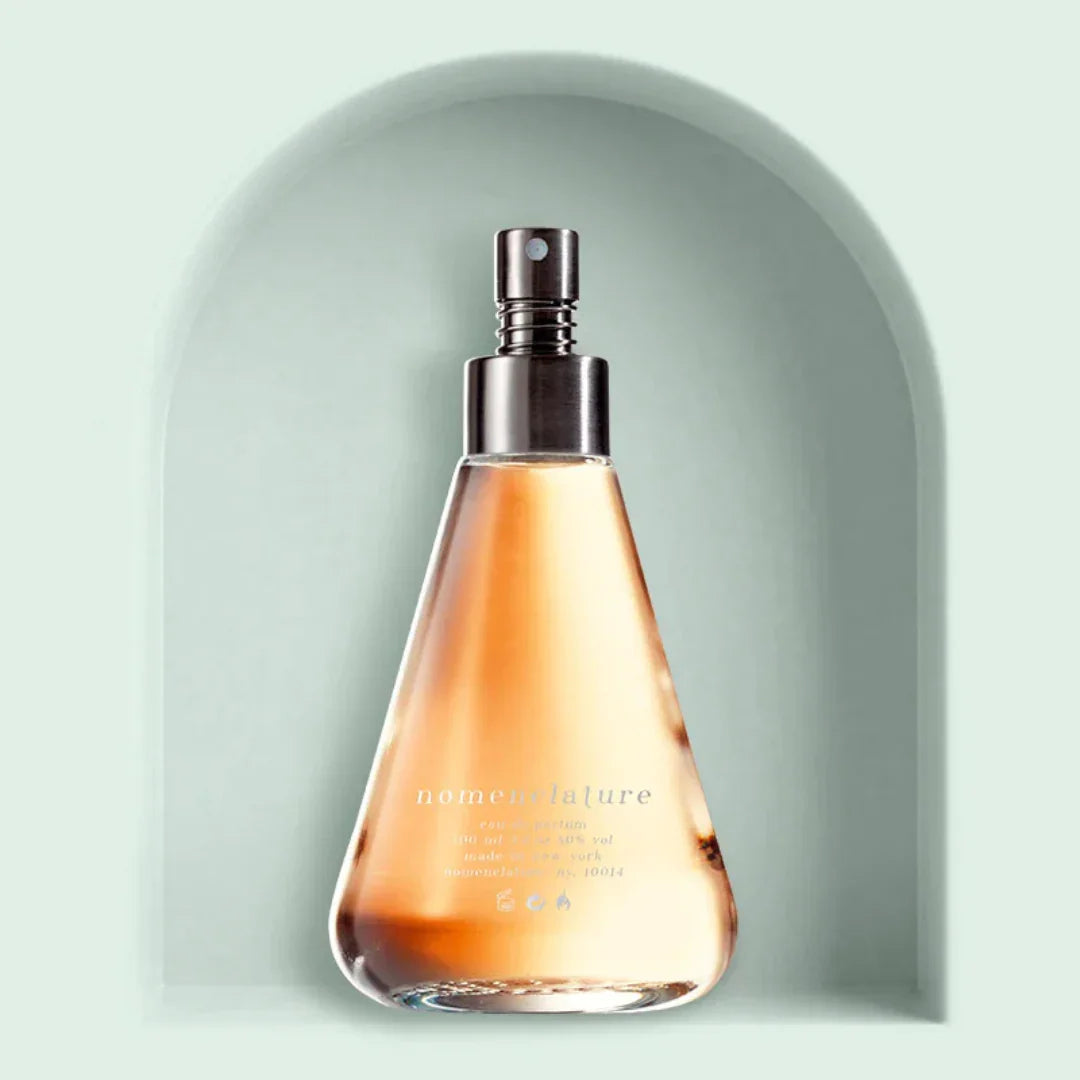 Parfümflasche in Kegelform mit Sprühverschluss, halb gefüllt mit hellbrauner Flüssigkeit. Beschriftet mit "nomenclature". Produktname: psy_cou. Anbieter: nomenclature.