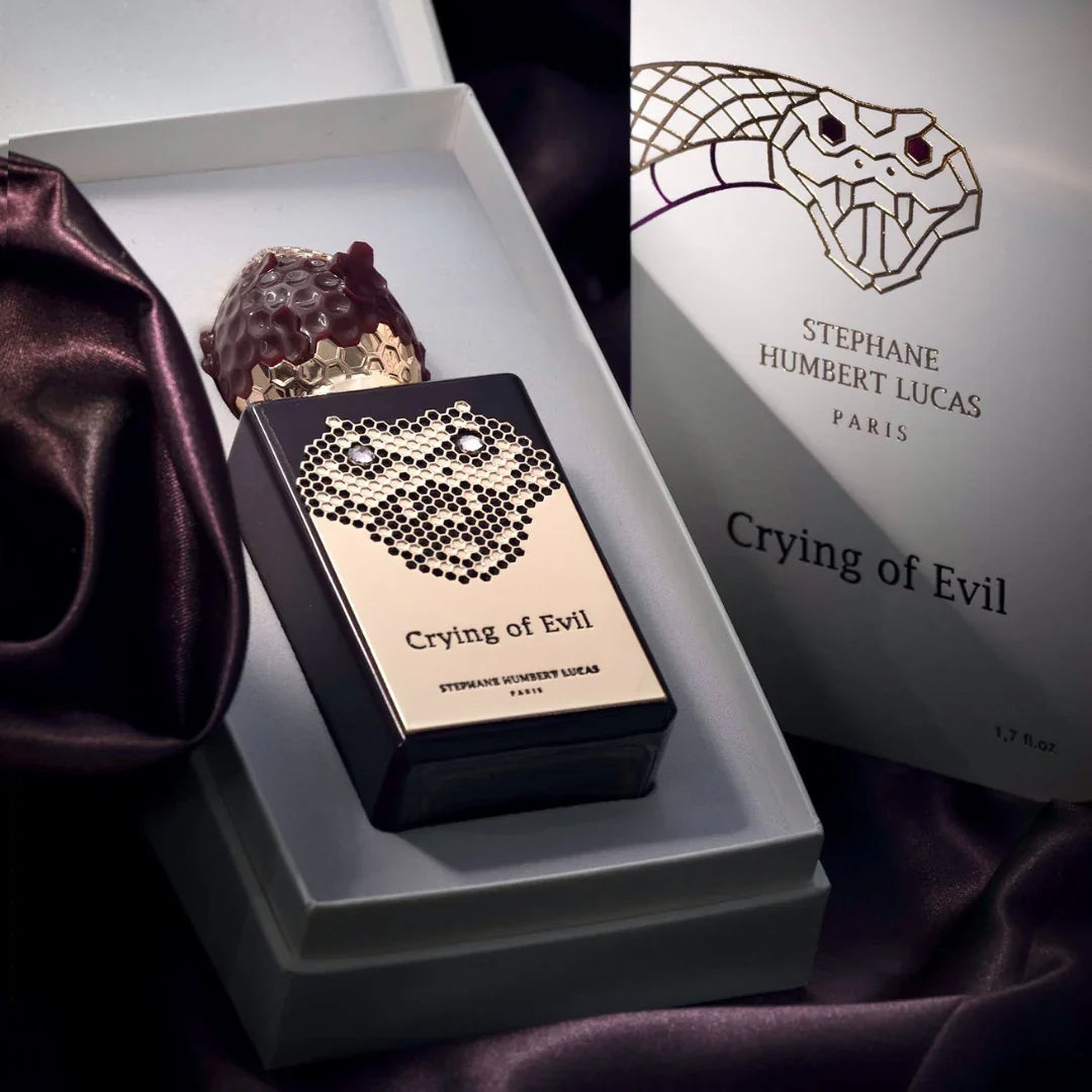 Parfümflasche "Crying of Evil" von Stéphane Humbert Lucas in schwarzer rechteckiger Form mit goldenen Akzenten und einer kunstvollen Schlangengrafik auf der Vorderseite, präsentiert in einer offenen Box.