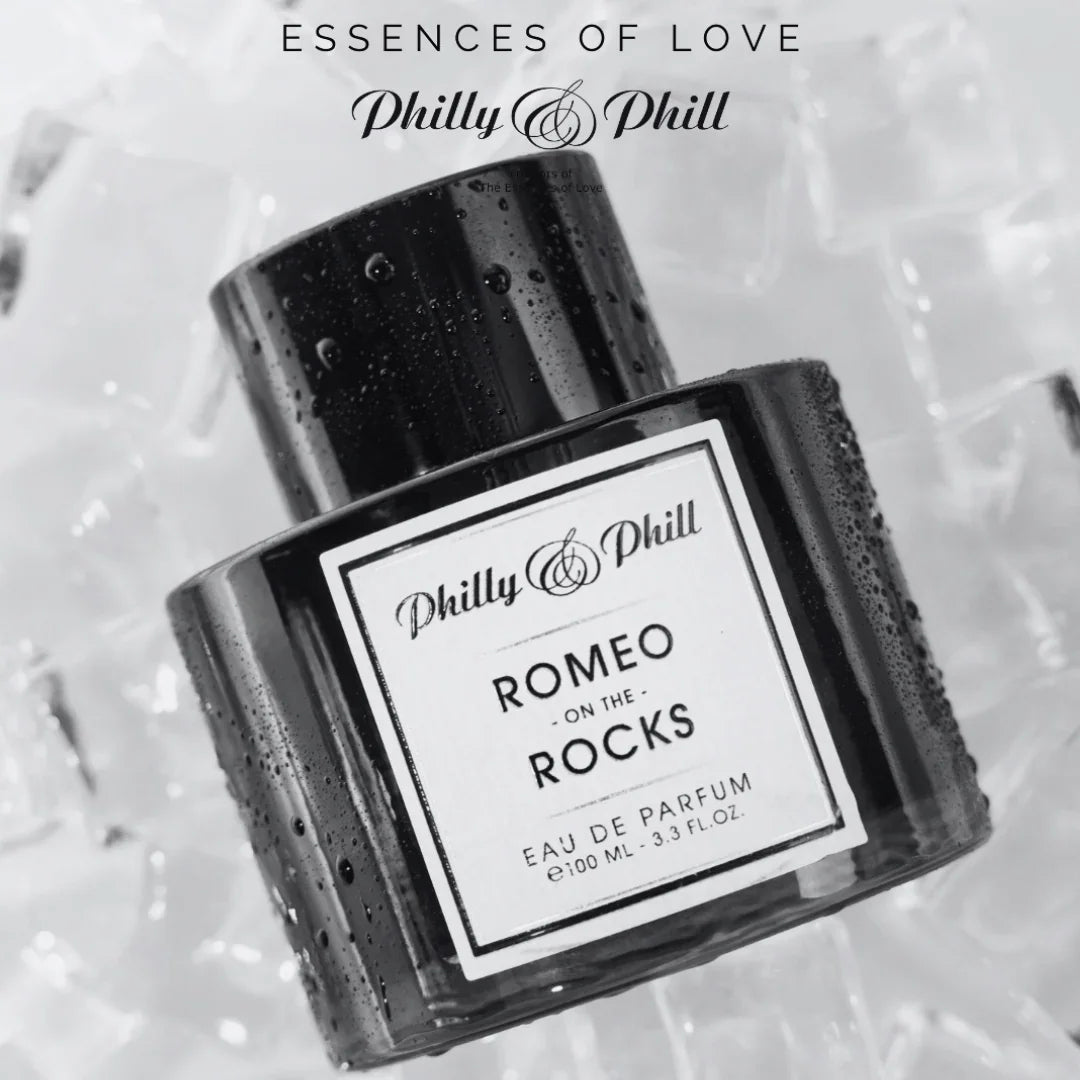 Parfümflasche "ROMEO ON THE ROCKS" von Philly & Phill auf Eiswürfeln, mit schwarzem Etikett und klarer Kappe.