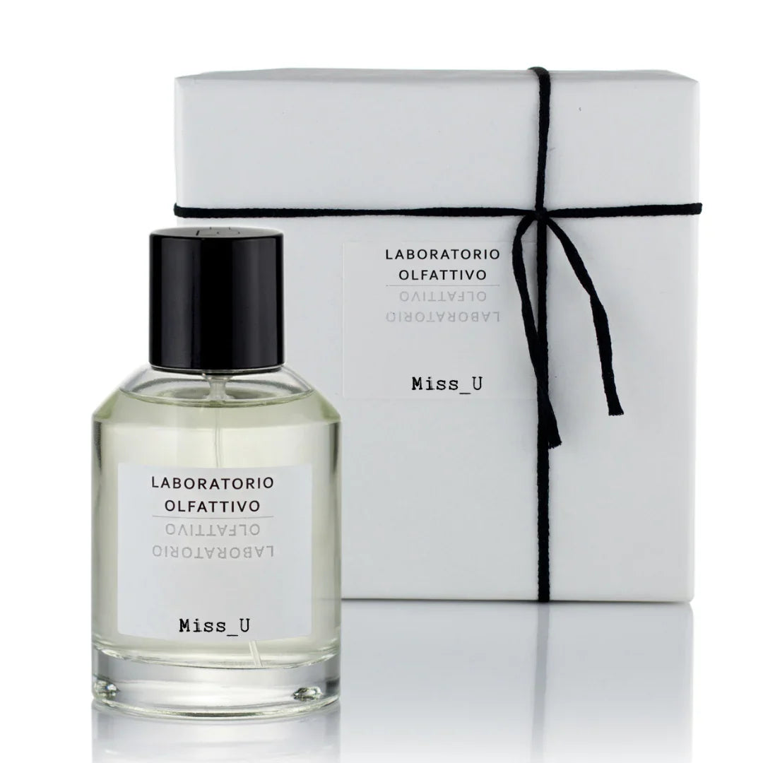 Parfumflakon mit schwarzem Verschluss und Etikett "Miss_U" von Laboratorio Olfattivo, neben passender Geschenkbox.