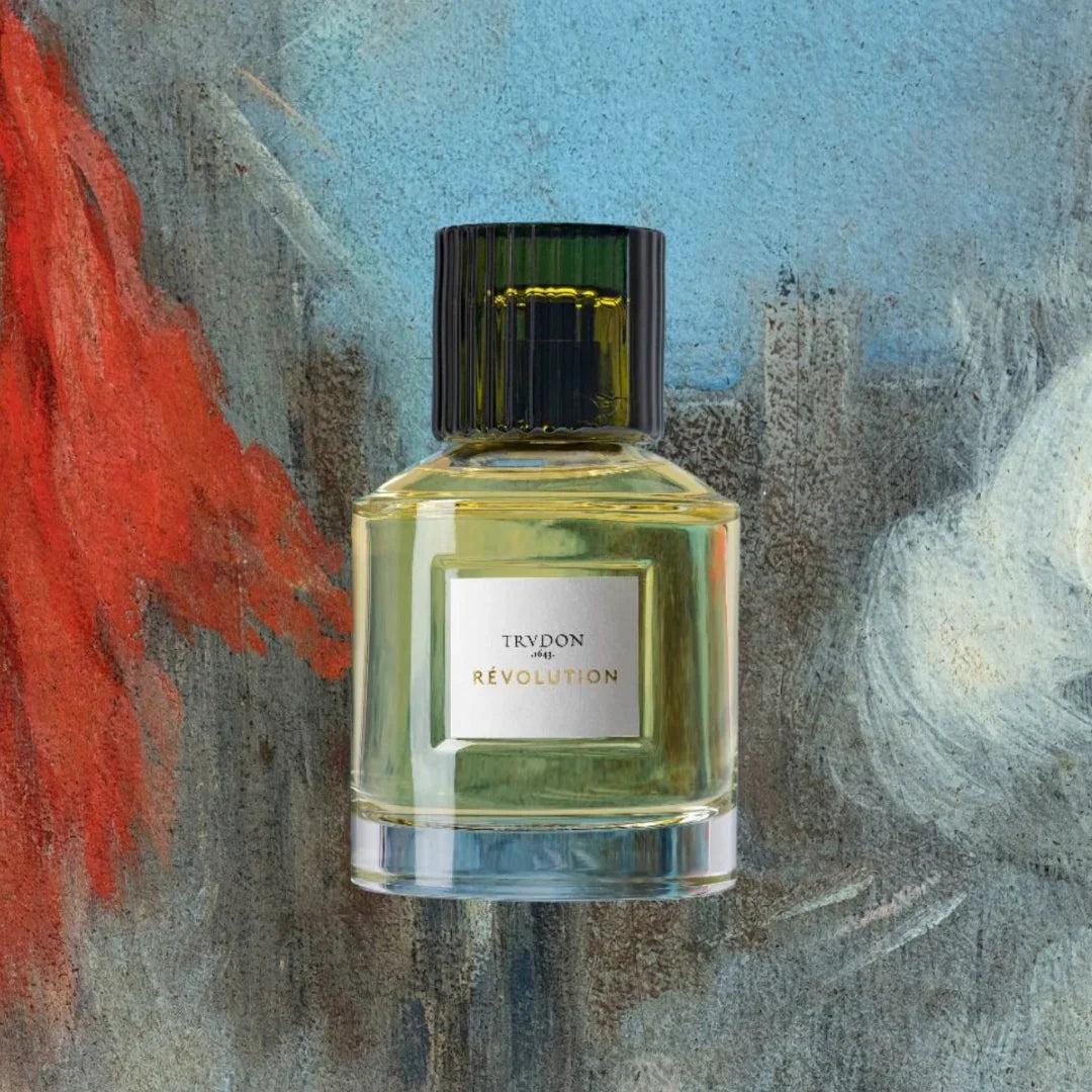 Glasflakon mit grünem Verschluss und weißem Etikett mit der Aufschrift "RÉVOLUTION" von Trudon.