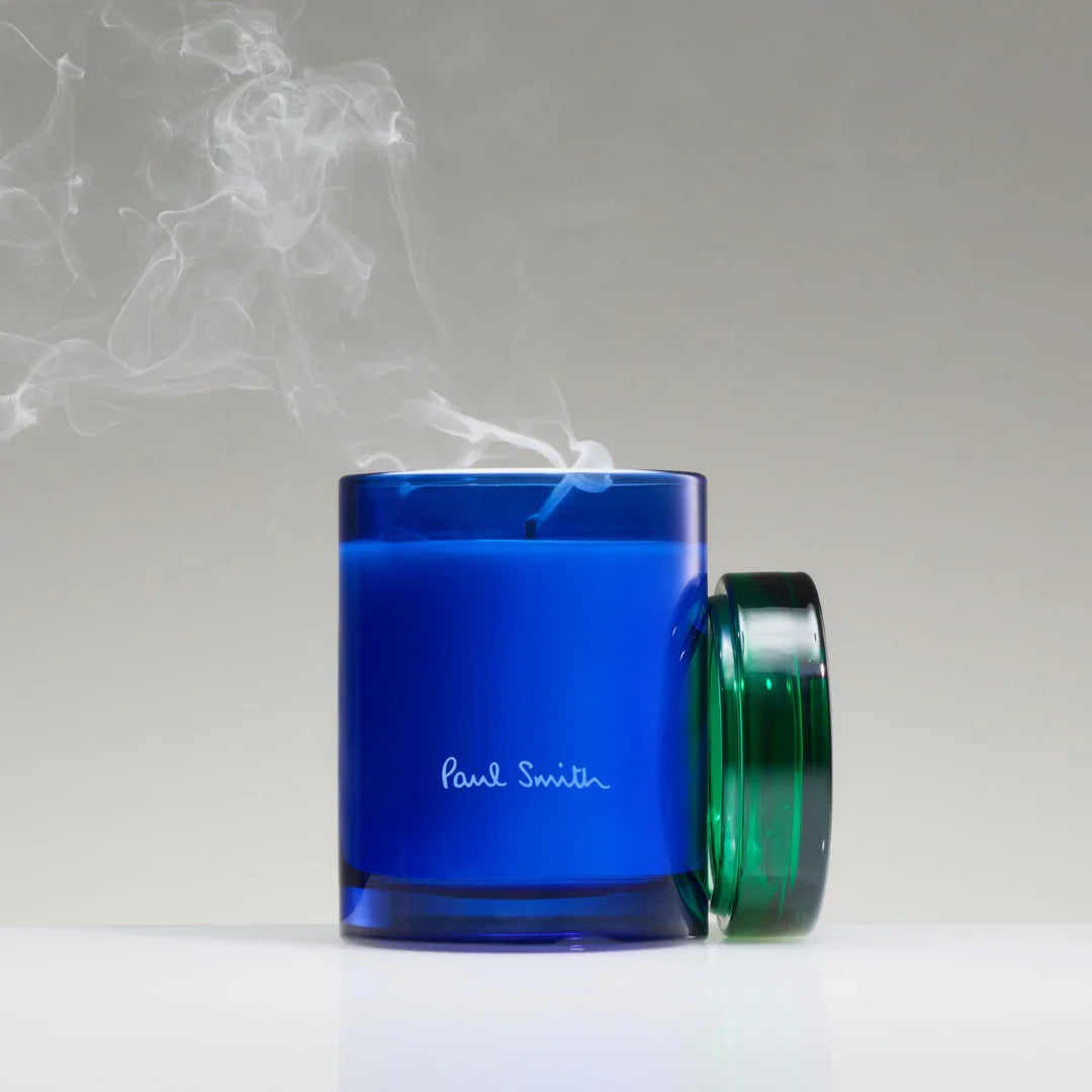 Duftkerze in einem blauen Glasbehälter mit abnehmbarem grünen Deckel, "Paul Smith" Schriftzug, Titel: Early Bird Duftkerze, Anbieter: Paul Smith.