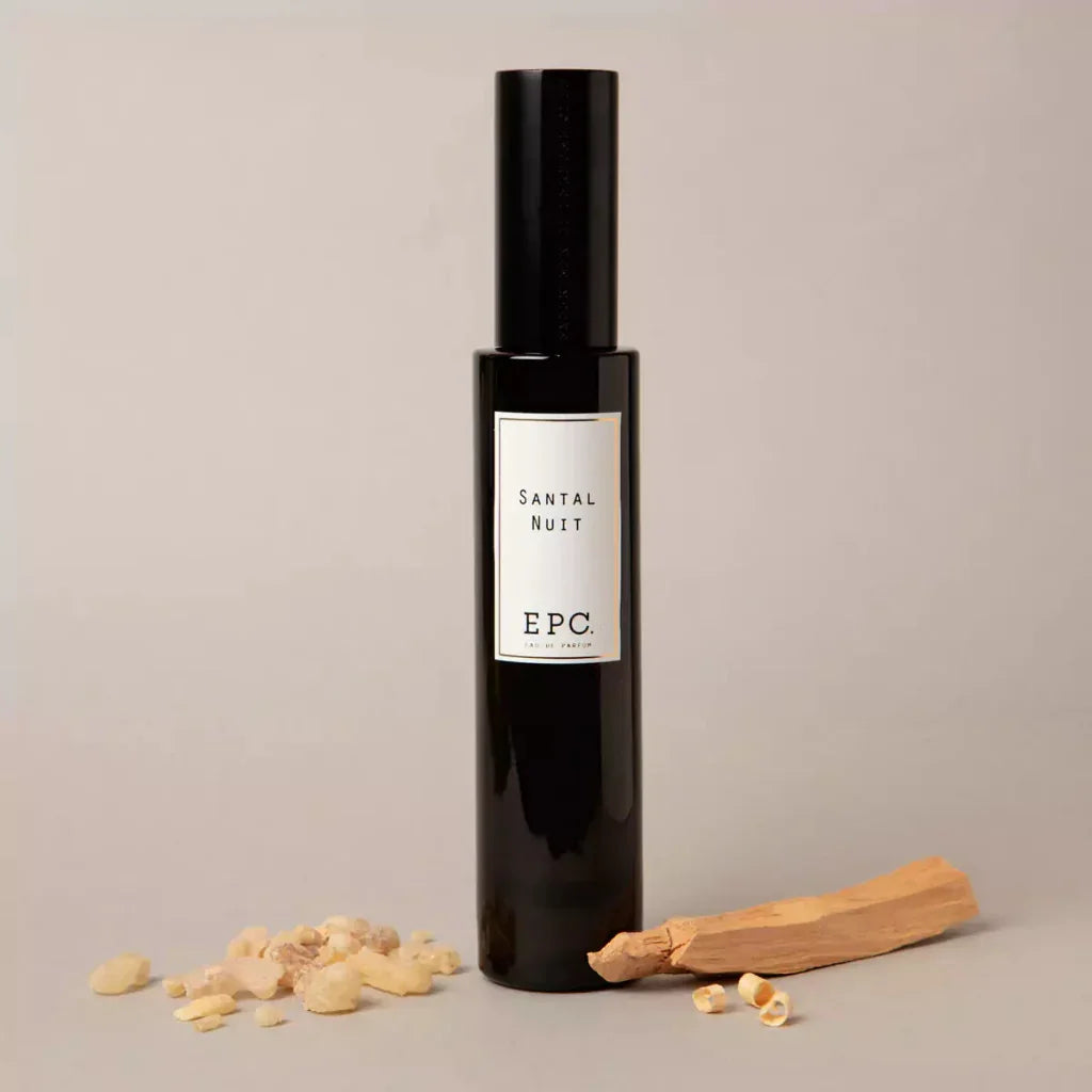 Ein schwarzes, zylindrisches Parfümfläschchen mit einem Etikett "Santal Nuit" und dem Label "EPC". Produkt von Experimental Perfume Club.