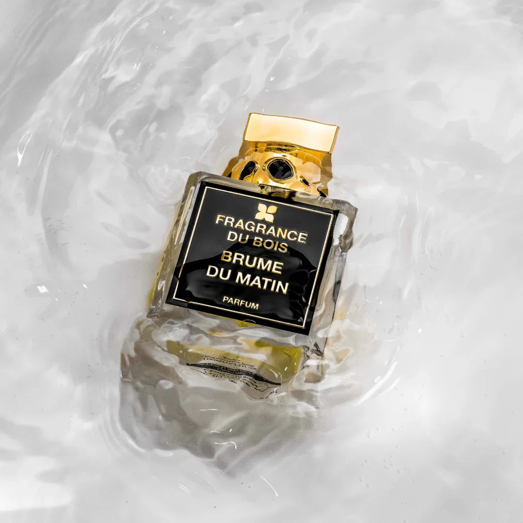Ein rechteckiger Parfümflakon "Brume du Matin" von "FRAGRANCE DU BOIS" mit schwarzem Etikett und goldener Kappe.