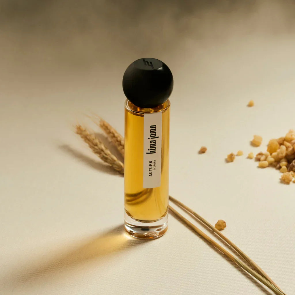 Ein Flakon mit Parfum "Seasons Collection - Autumn in Lhoka" von hima jomo. Der Flakon ist zylindrisch mit schwarzem Verschluss.