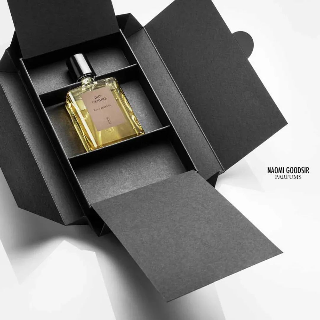 Parfümflakon "Iris Cendré" von Naomi Goodsir, in einer eleganten schwarzen Schachtel präsentiert. Der Flakon hat eine rechteckige Form mit schwarzem Verschluss.