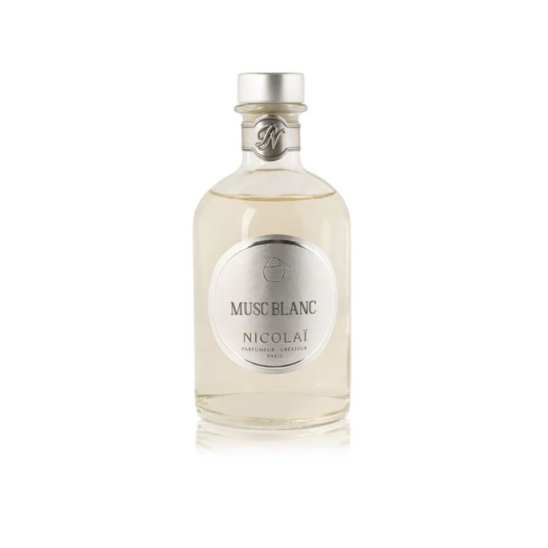 Glasflasche mit silbernem Verschluss und rundem Etikett, darauf der Schriftzug "Musc Blanc". Produkt: Musc Blanc - Diffuser, Anbieter: Nicolaï.