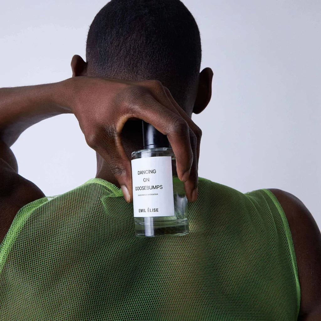 Parfümflasche "Dancing on Goosebumps" von Emil Élise wird von einer Person in den Händen gehalten. Die Person trägt ein grünes Oberteil.