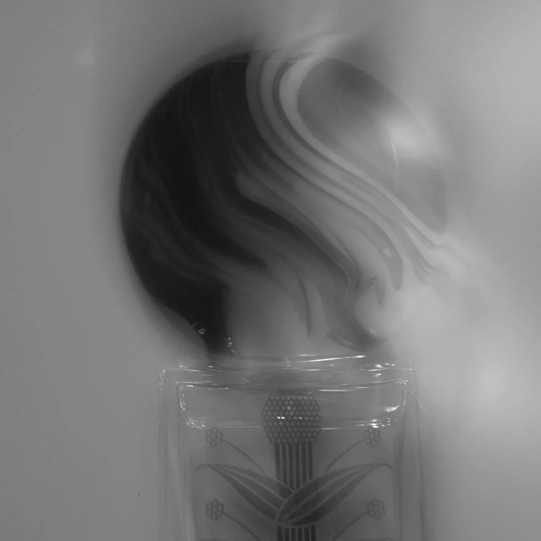 Duftflakon mit rundem, marmoriertem Deckel und floralen Motiven auf dem Glas. Produkt: Silphium, Hersteller: Stora Skuggan.