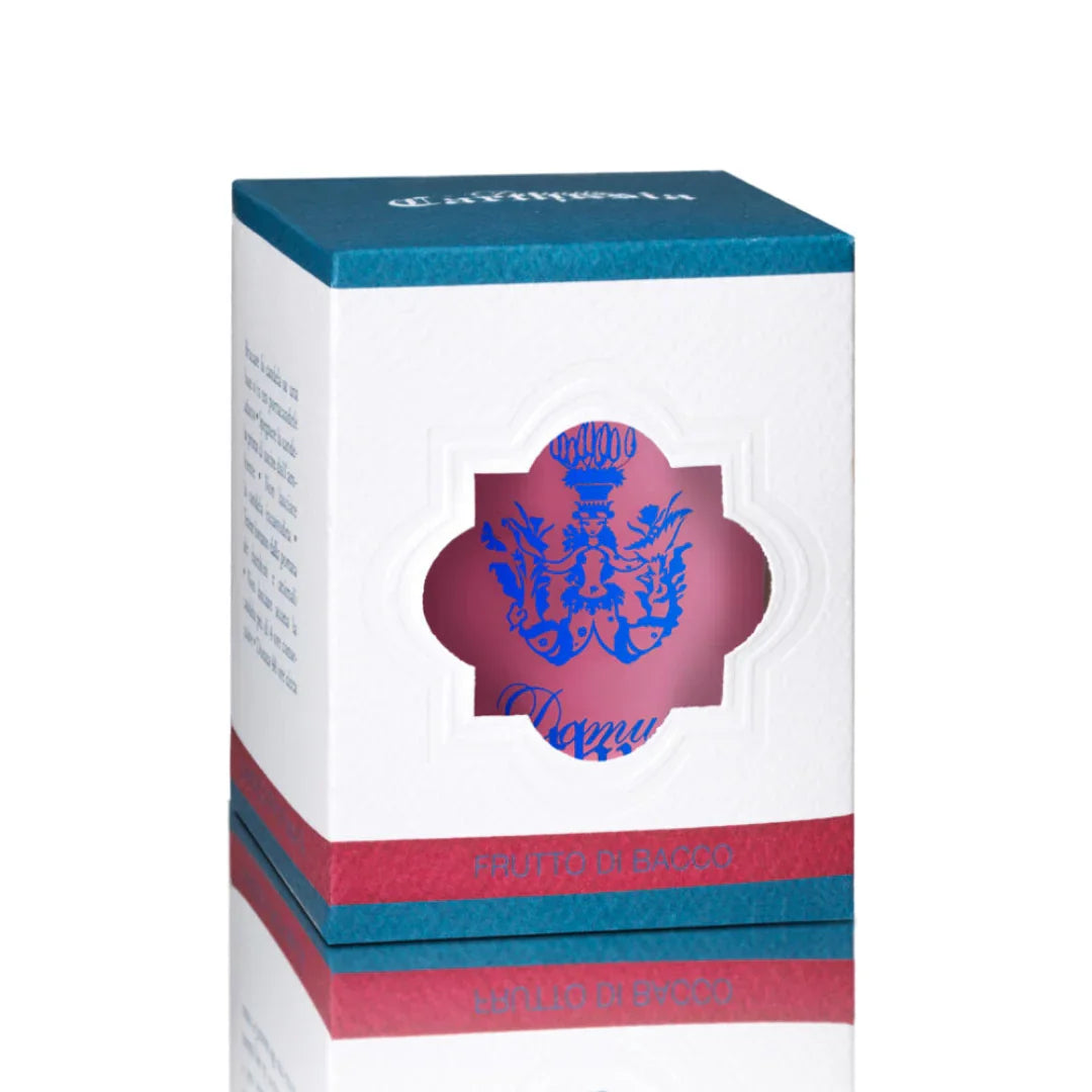 Weiße Kartonverpackung mit blauer Schrift „Frutto di Bacco“ und einem Fenster, das eine Duftkerze von Carthusia zeigt.