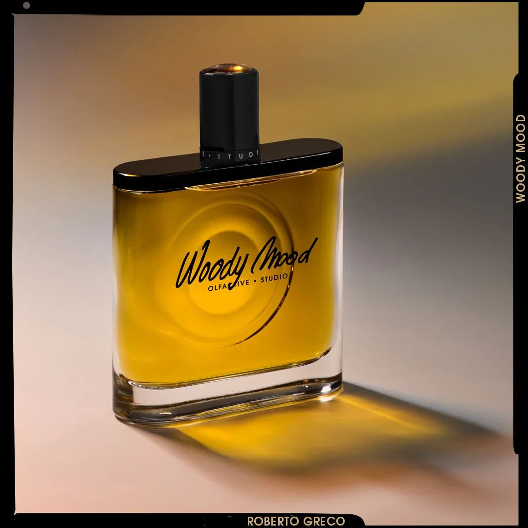 Parfumflakon "Woody Mood" von Olfactive Studio, rechteckig, transparent, mit schwarzem Verschluss und Schriftzug.