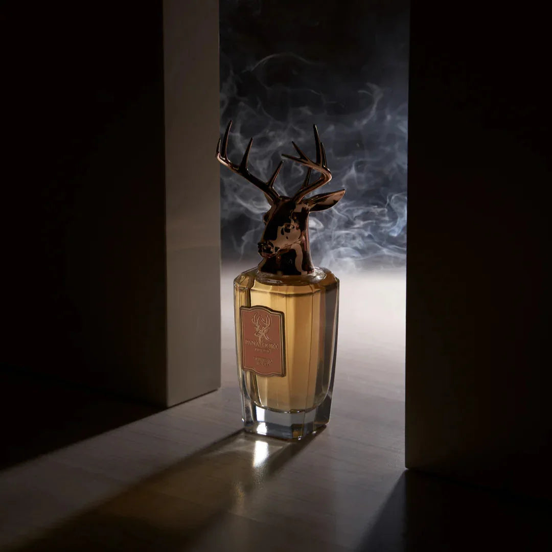 Flakon "Imperial Wood" von Pana Dora mit Hirschkopf-Deckel, aus Glas, enthält eine bernsteinfarbene Flüssigkeit.