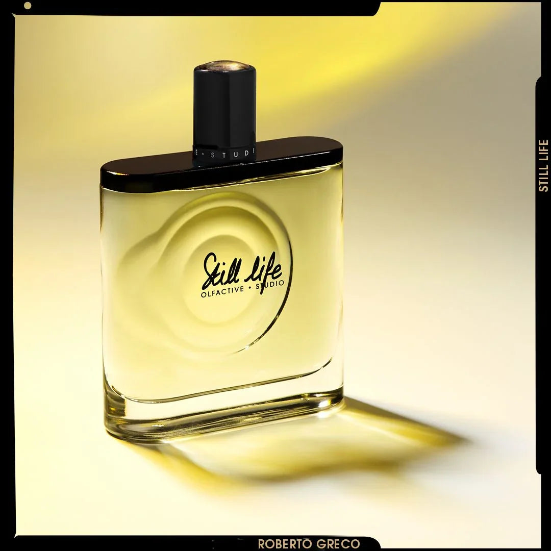 Parfümflakon von Still Life, Olfactive Studio, mit schwarzem Verschluss und transparentem Glas, gelbe Flüssigkeit sichtbar.