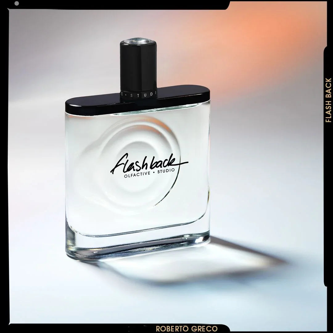 Ein rechteckiger Parfümflakon aus Glas mit schwarzem Verschluss und dem Schriftzug "Flash Back Olfactive Studio" auf der Vorderseite.