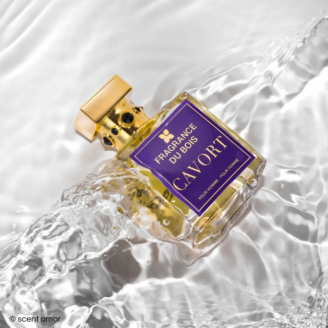 Parfümflakon mit der Aufschrift "Cavort" und dem Logo "FRAGRANCE DU BOIS", schwimmend auf Wasser. Der Flakon hat einen goldenen Verschluss.