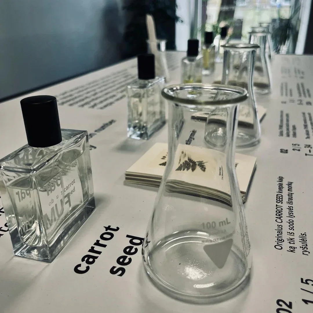 FUMparFUM "Figueres" Parfümflaschen auf einem Tisch. Im Vordergrund ein Messbecher, im Hintergrund weitere Flaschen.