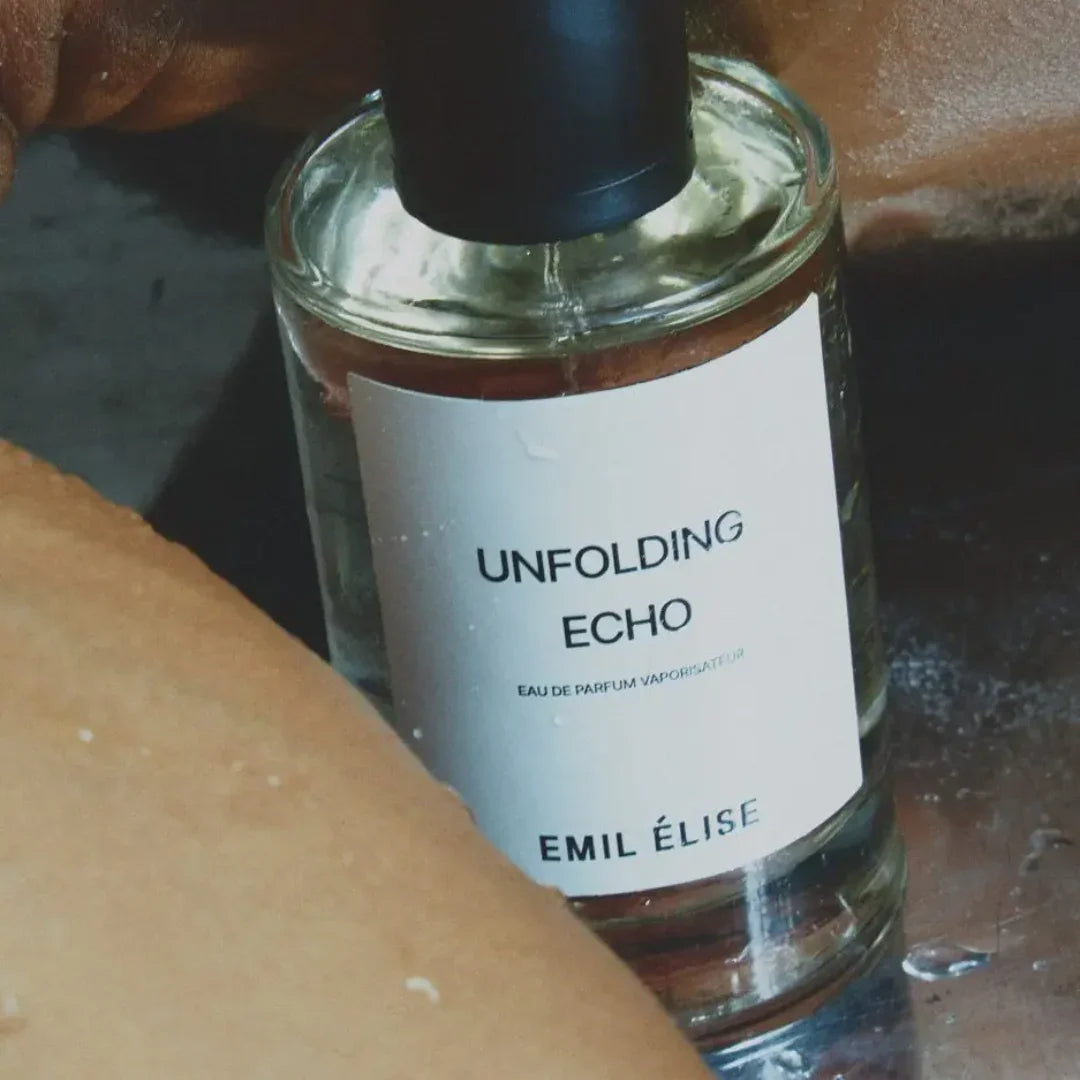 Parfümflakon "Unfolding Echo" von Emil Élise mit schwarzem Verschluss und weißem Etikett mit schwarzer Schrift.