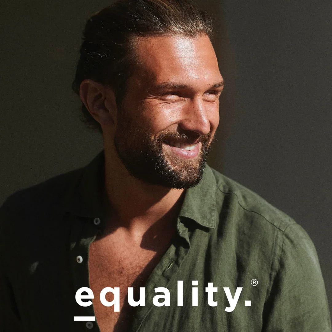 Mann mit Bart lächelt. Er trägt ein grünes Hemd. Produktname: equality. Anbieter: equality.