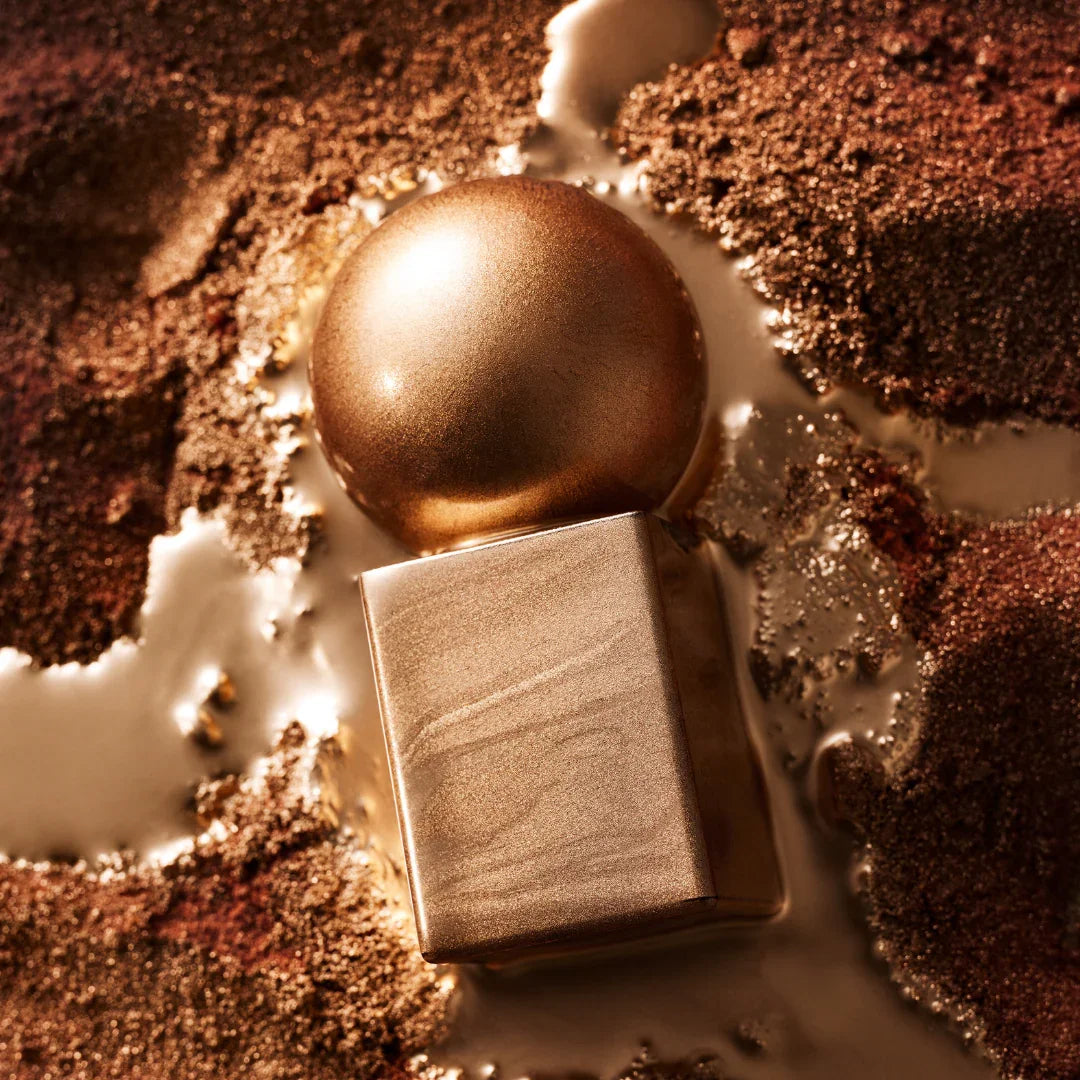 Parfümflakon "Azalai" von Stora Skuggan, mit einem goldenen, kugelförmigen Verschluss und quadratischem Flaschenkörper.