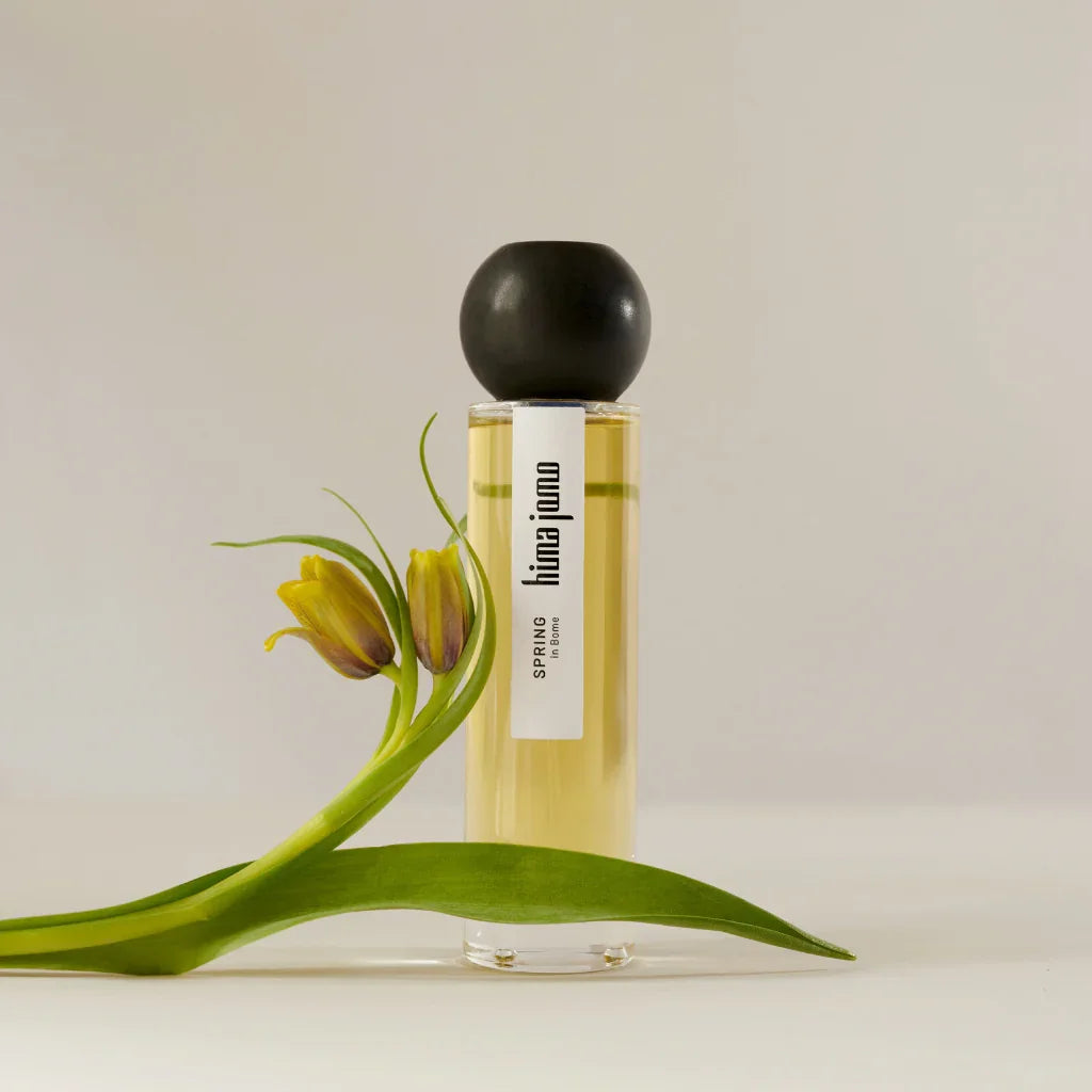 Flakon mit gelbem Inhalt, schwarzem Verschluss, „hima jomo“ Aufschrift. Titel: Seasons Collection - Spring in Bome. Anbieter: hima jomo.