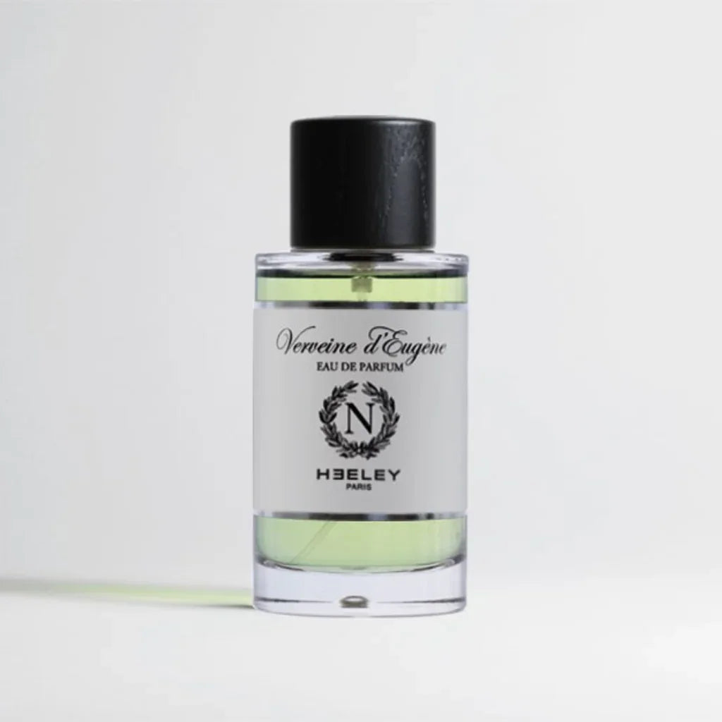 Klares Parfümflakon mit schwarzem Verschluss, "Verveine d'Eugène" von Heeley auf dem Etikett in schwarzer Schrift.