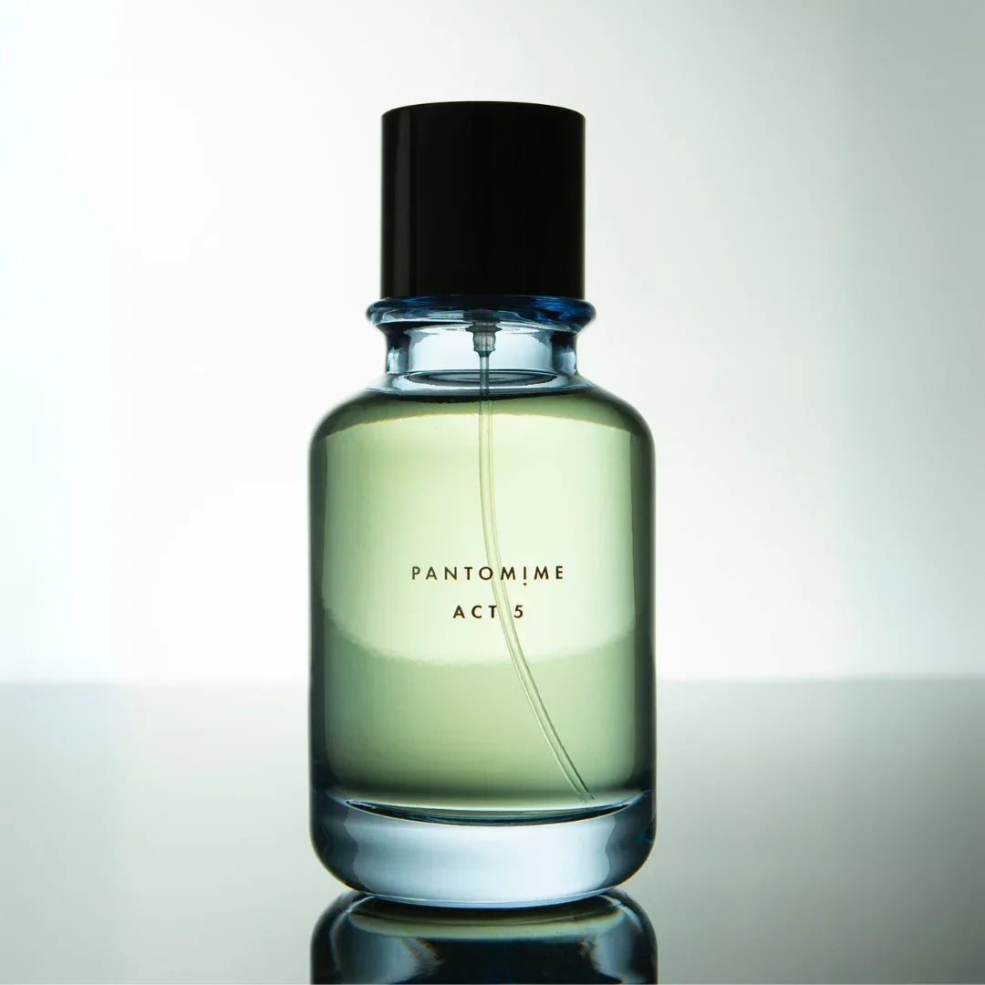 Klares Parfümfläschchen mit schwarzem Verschluss, auf dem "PANTOMIME ACT 5" steht. Hersteller: Pantomime.