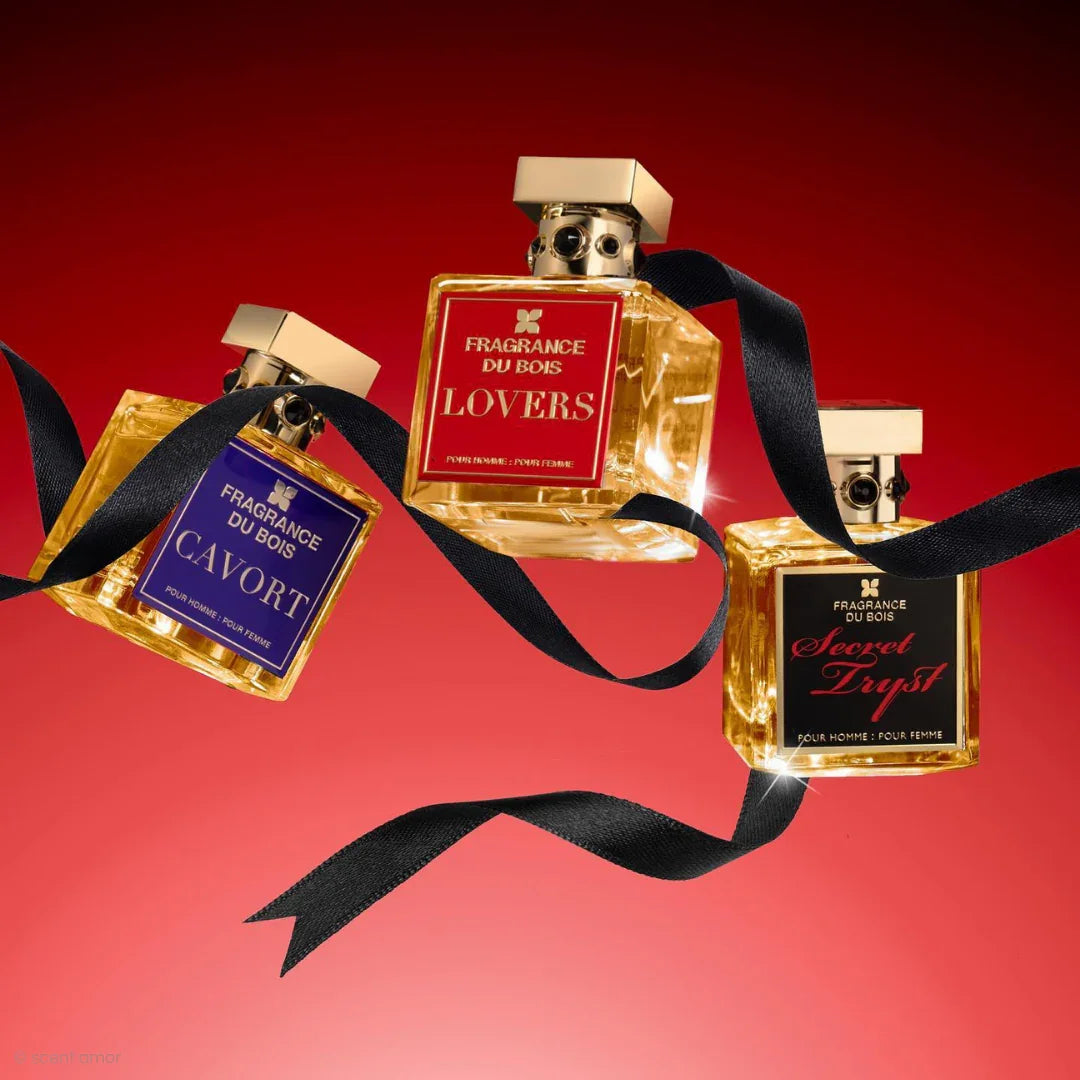 Drei Parfümflaschen mit goldenen Kappen und Etiketten in Rot und Lila. Produkt: Lovers. Anbieter: FRAGRANCE DU BOIS.