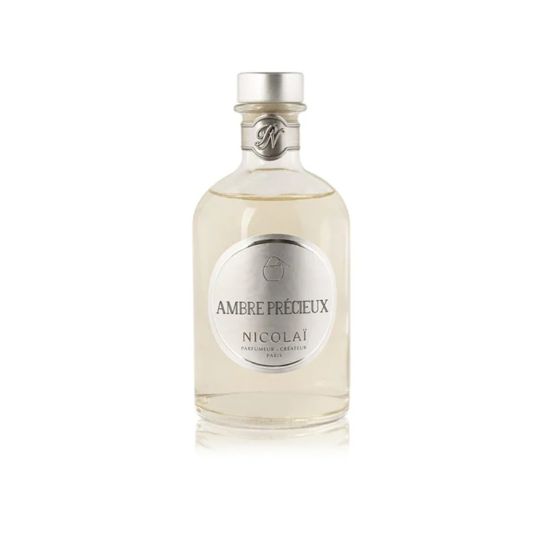 Klarglasflakon mit silbernem Verschluss, auf dem Etikett steht "Ambre Précieux" und der Herstellername "Nicolaï".