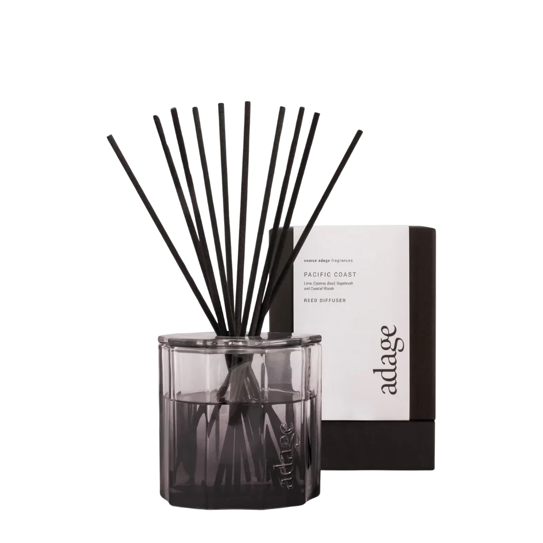 Pacific Coast Diffuser von source adage, in einem transparenten Glasbehälter mit schwarzen Duftstäbchen.