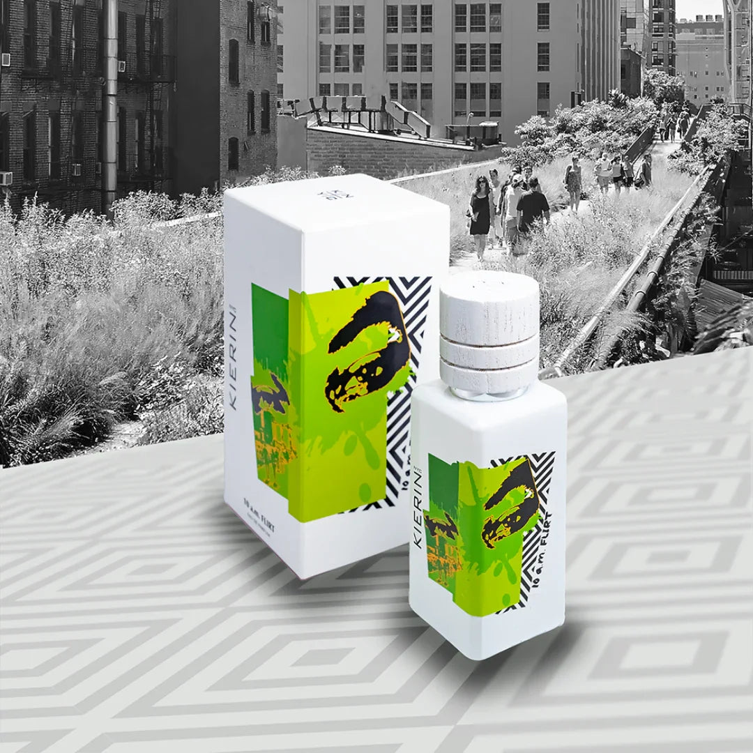 Parfümflasche und Verpackung von "10 a.m. Flirt" des Anbieters "Kierin NYC". Weißes Fläschchen mit grünem, künstlerischem Etikett.