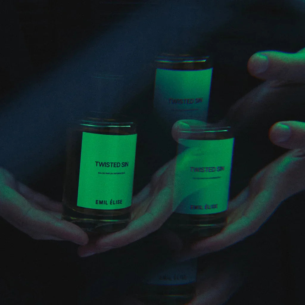 Parfümflasche "Twisted Sin" von Emil Élise, mehrfach reflektiert; Flasche mit schwarzem Deckel und weißem Etikett.