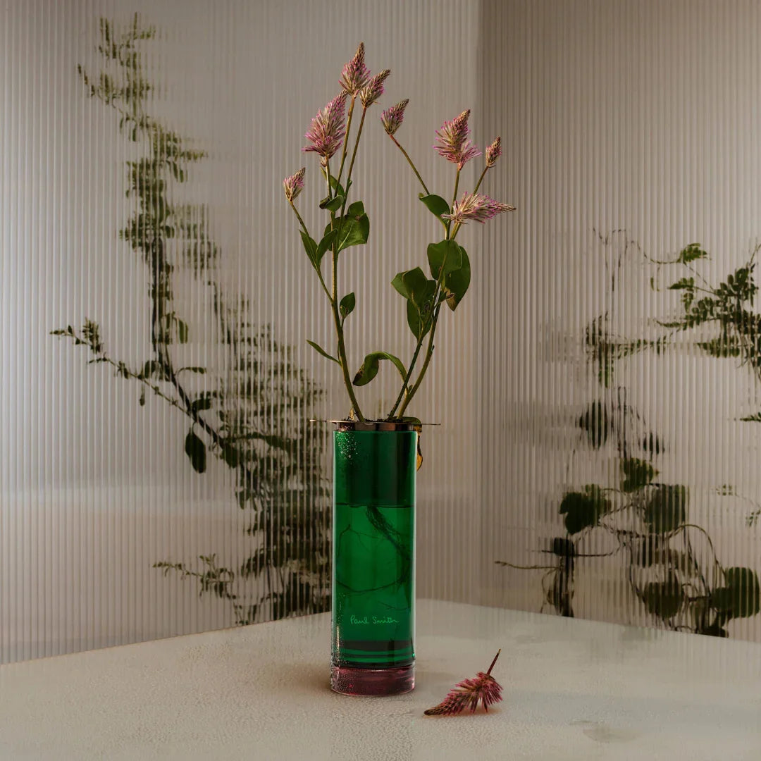 Grüner Botanist Diffuser von Paul Smith, zylinderförmig mit Pflanzenstängeln und Blüten, die herausragen.