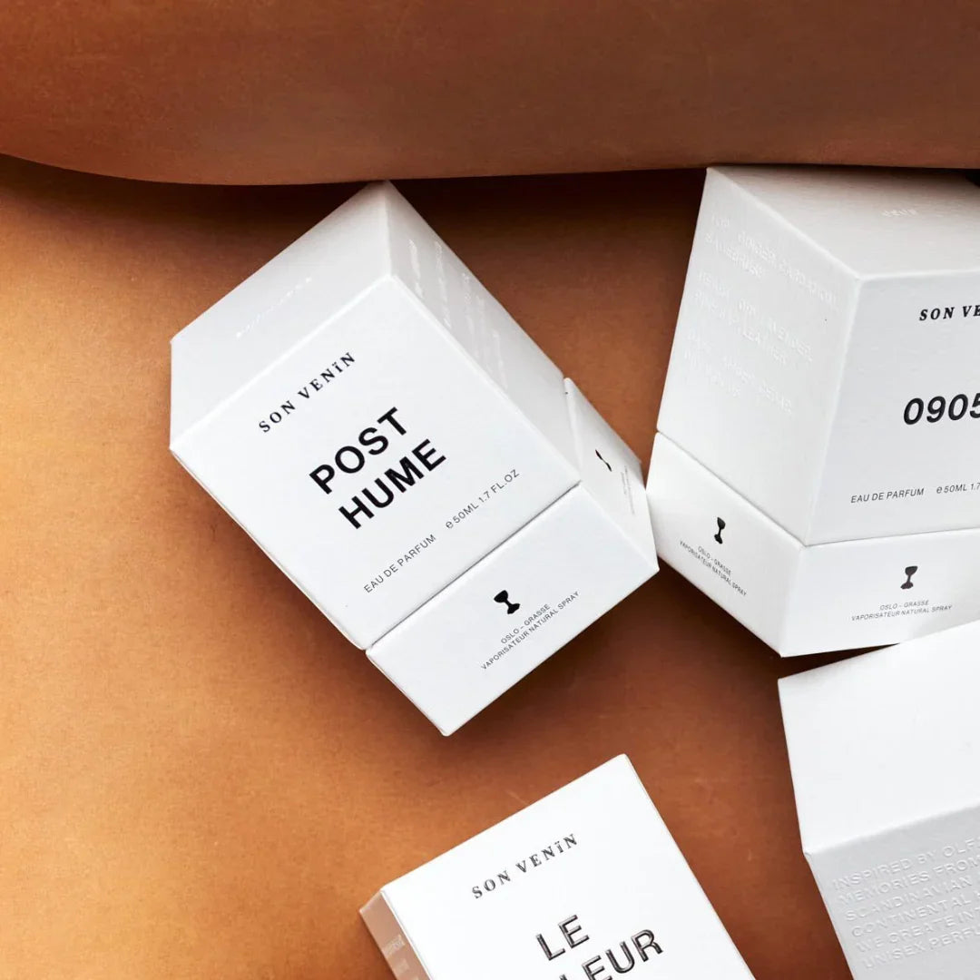 Weiße Verpackungsschachteln mit schwarzem Text, "Posthume" und "SON VENÏN". Mehrere Schachteln sind sichtbar.