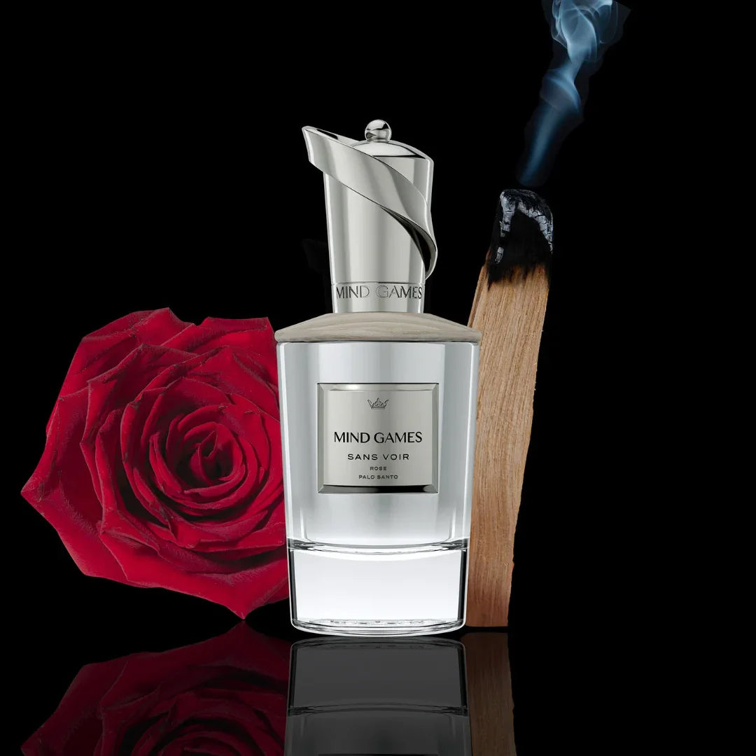 Der Duft "Sans Voir" von Mind Games: Flakon mit silbernem Verschluss, rote Rose und brennendes Holz im Hintergrund.