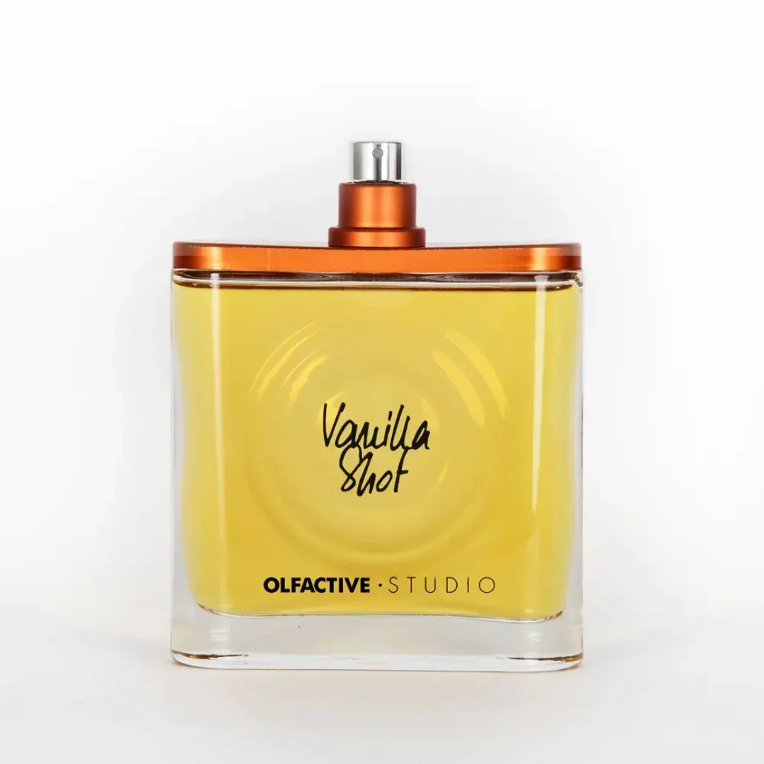 Parfümflasche "Vanilla Shot" von Olfactive Studio mit gelber Flüssigkeit und orangem Sprühkopf.