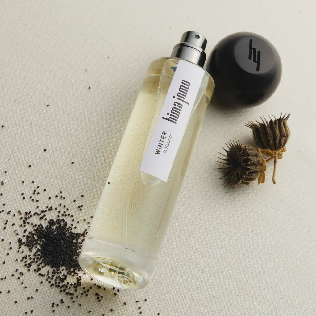 Durchsichtige Glasflasche mit der Aufschrift "Winter in Manaslu" von "hima jomo". Schwarzer Schraubverschluss. Enthält durchsichtiges Parfüm.