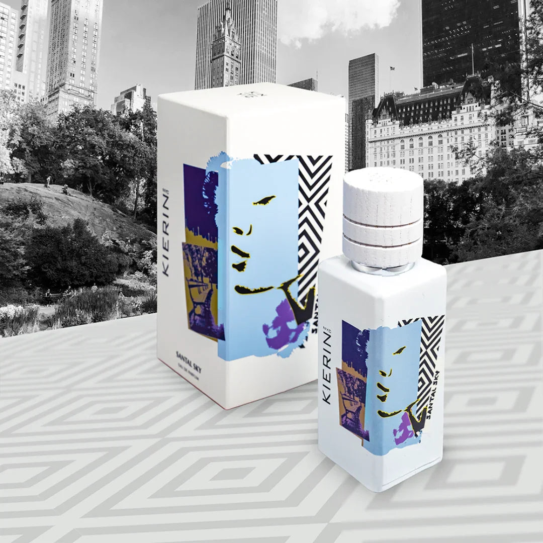 Flakon des „Santal Sky“ Parfüms von Kierin NYC neben der passenden Verpackung, verziert mit einem abstrakten Gesichtsmotiv.