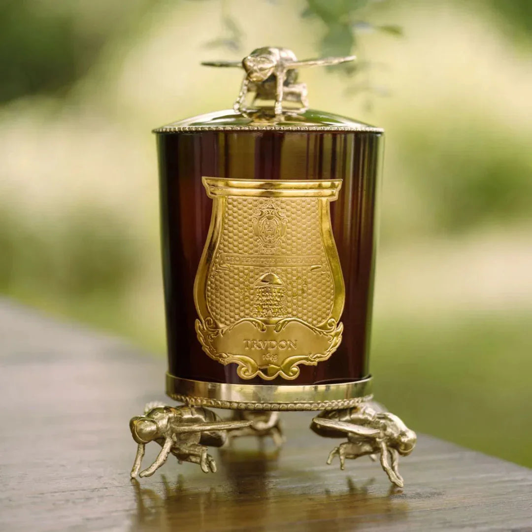CIRE - Duftkerze von Trudon, in einem braunen Glasbehälter mit goldenen Bienenverzierungen und einem goldenen Emblem.