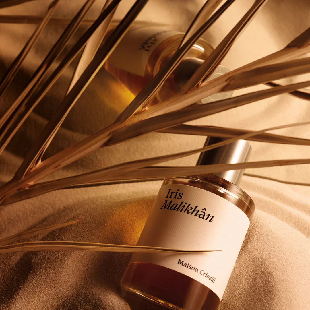 Parfümflakon "Iris Malikhan" von Maison Crivelli, mit silbernem Verschluss und sandfarbenem Hintergrund.
