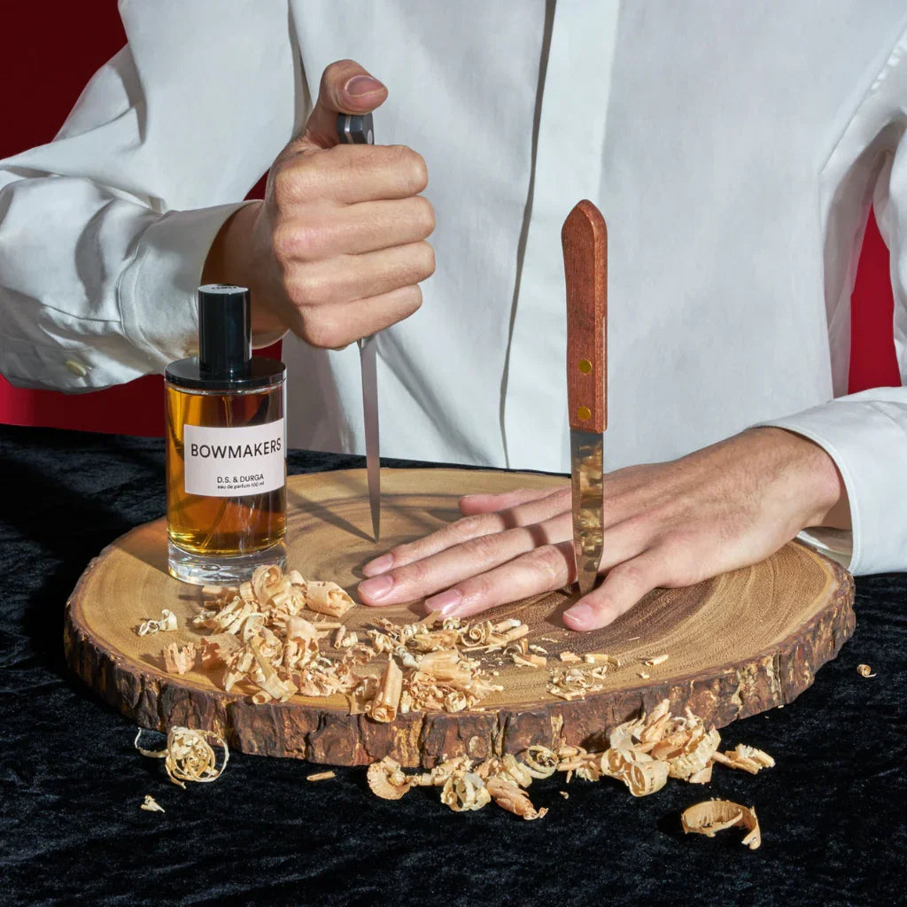D.S. & Durga BOWMAKERS Eau de Parfum mood Flakon auf Holzbrett Hand und Messer scent amor
