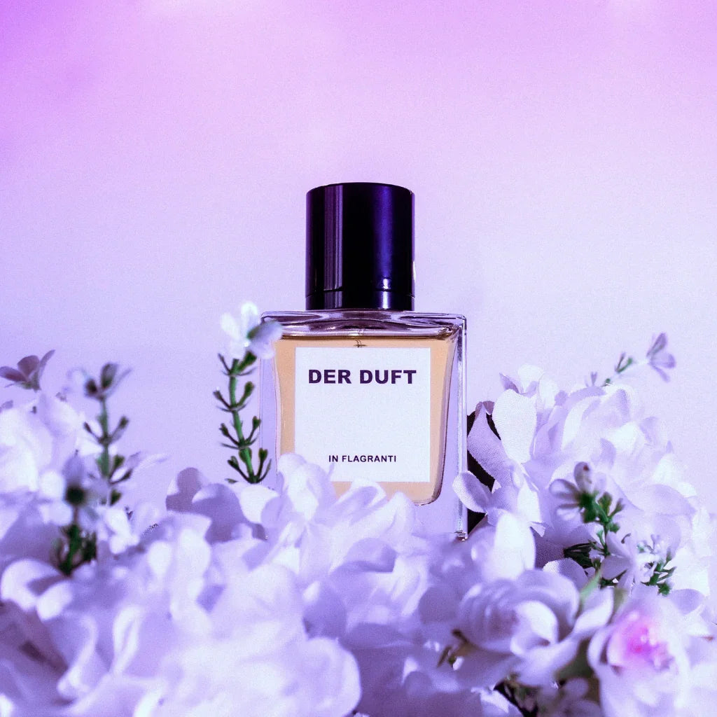der duft in flagranti flakon auf blumen lilanes licht