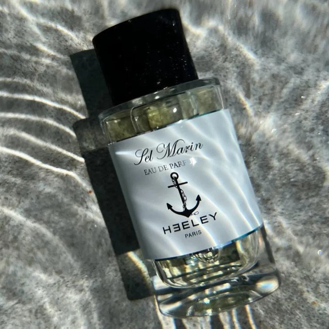 Heeley Flakon im Wasser vor Sand scent amor